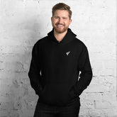 Man wearing a black hoodie from the Core Collection, showcasing comfort and style against a brick wall.
