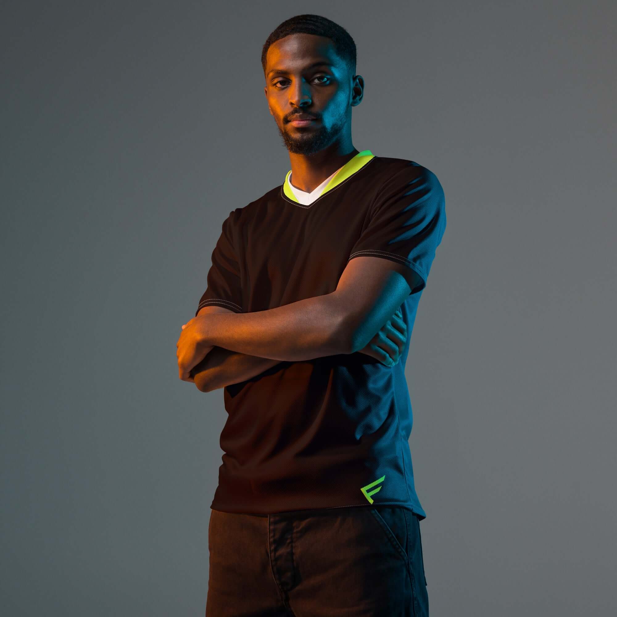 Model wearing CoreDry V-Neck Training Jersey in Black with Lime Trim, showcasing lightweight athletic performance.