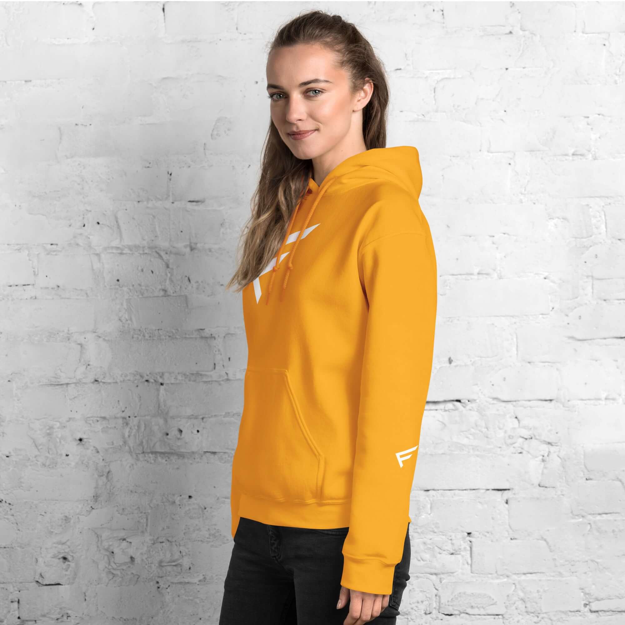 Woman wearing a bright yellow hoodie with signature 'F' emblem, styled for comfort and bold movement.