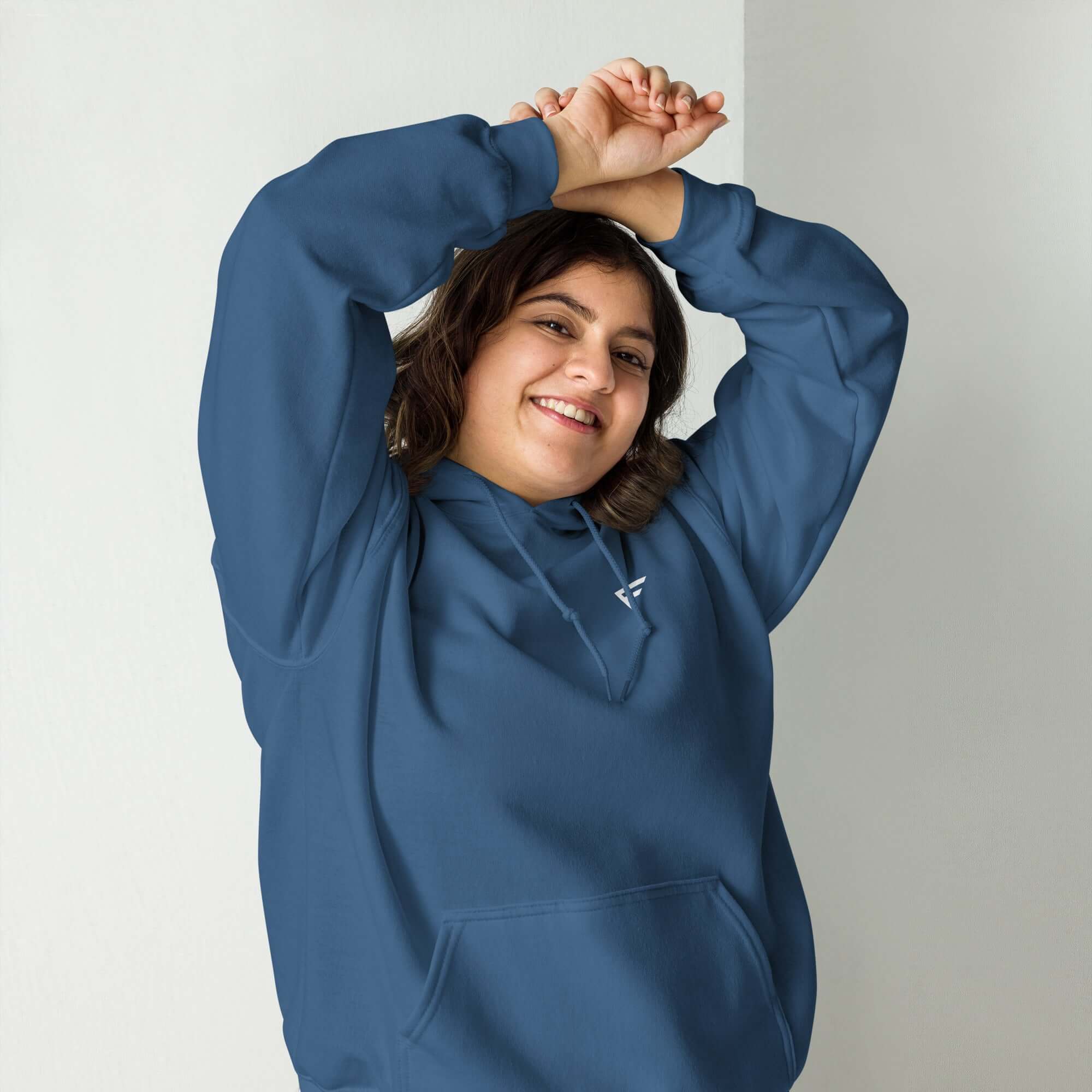 Smiling woman wearing a cozy blue hoodie, showcasing everyday comfort and effortless style for any occasion.