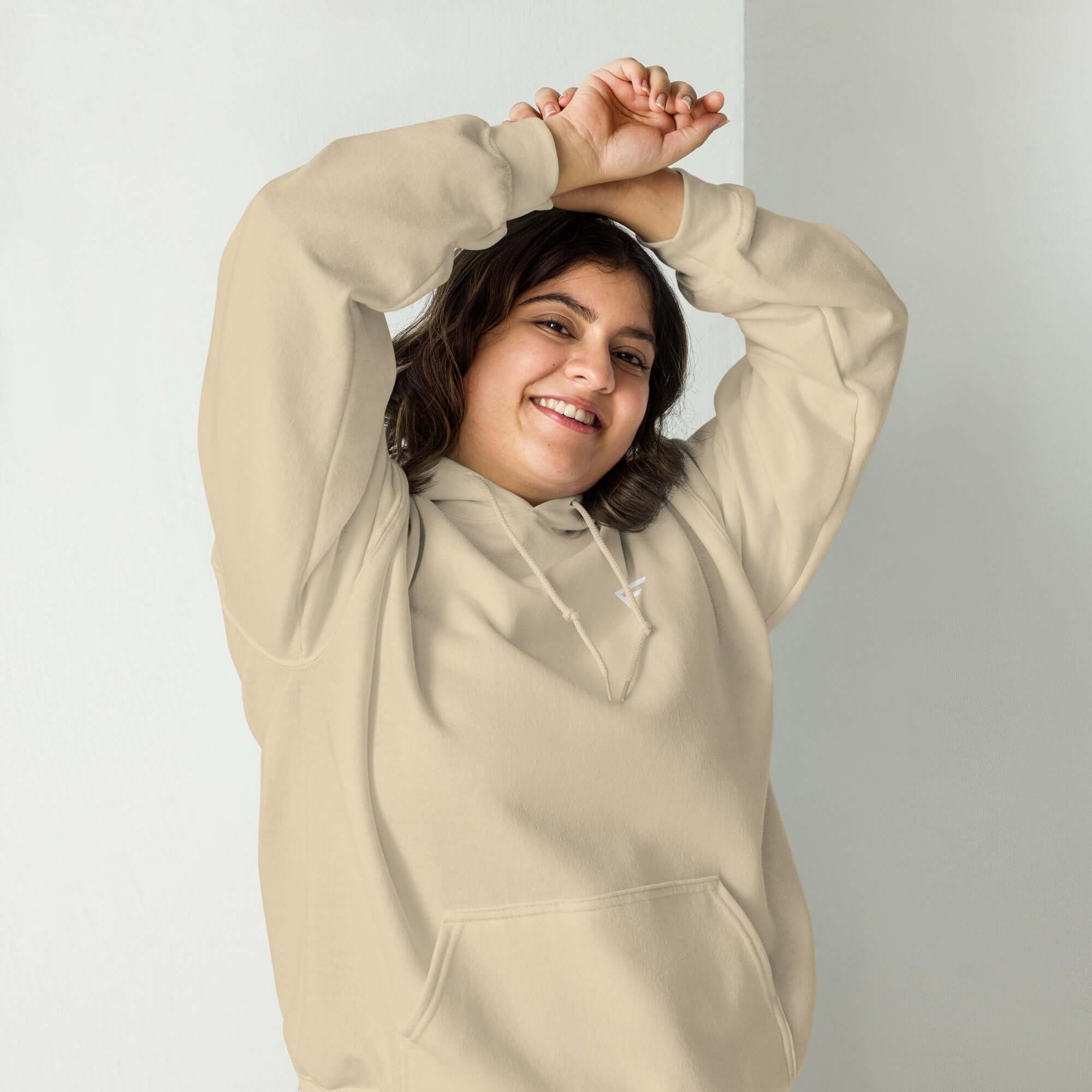 Smiling woman in a soft beige hoodie, showcasing everyday comfort and stylish casual wear.